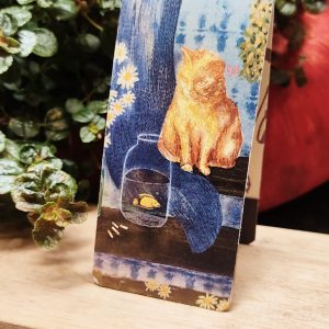 Gato que mira a un pez marcapáginas con imán